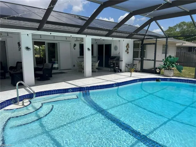 Screened pool enclosure featuring a pool with steps, a concrete patio, and multiple sliding glass doors