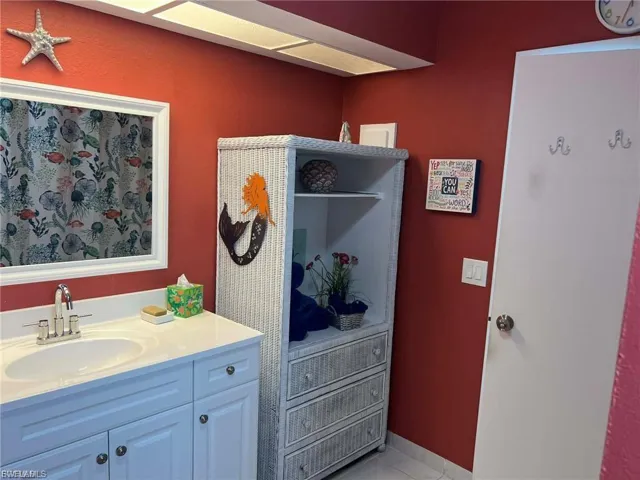 White vanity with integrated sink, chrome faucet, and white countertop