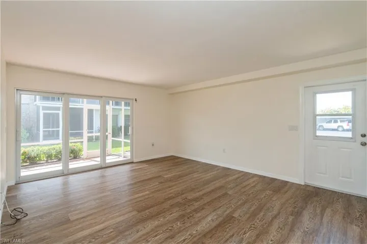 Empty room featuring dark hardwood / wood-style flooring