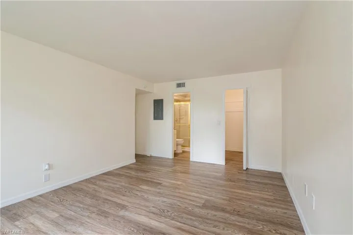 Empty room with electric panel and light hardwood / wood-style flooring