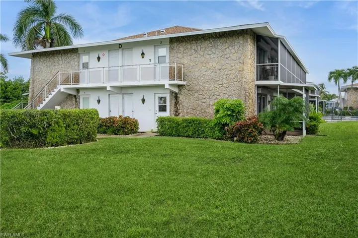 Rear view of property with a balcony and a yard