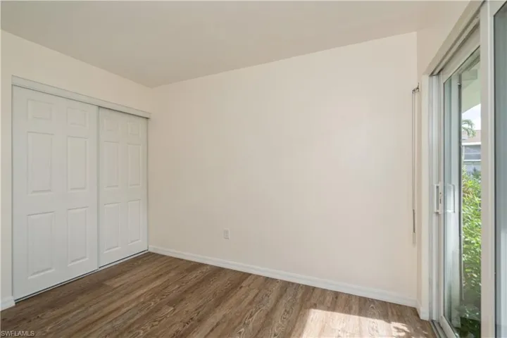 Unfurnished bedroom with a closet and dark hardwood / wood-style floors
