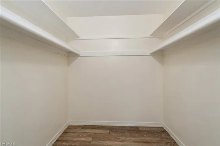 Spacious closet featuring dark hardwood / wood-style floors