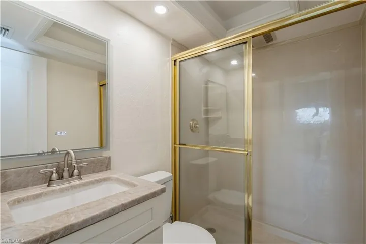 Bathroom featuring vanity, toilet, and walk in shower
