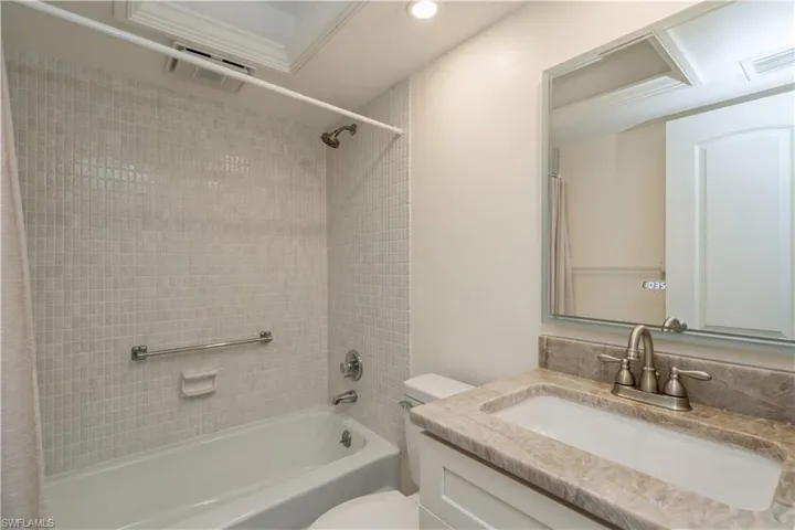 Full bathroom featuring ornamental molding, vanity, toilet, and shower / tub combo with curtain