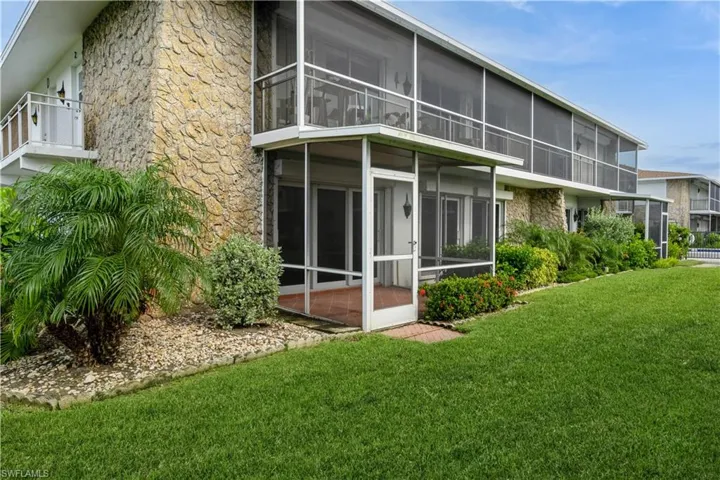 Rear view of house featuring a sunroom and a yard