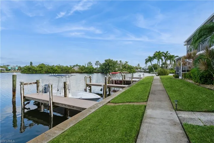 Dock area with a water view and a yard