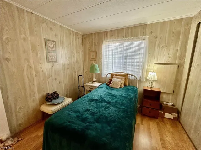 Bedroom featuring wood walls and hardwood / wood-style flooring
