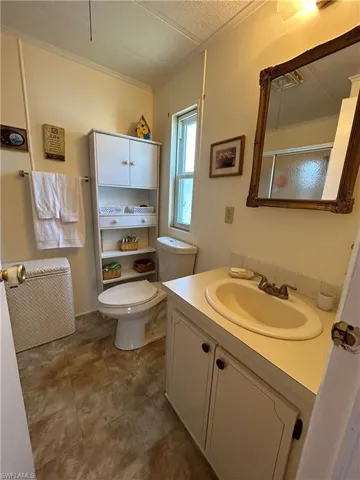 Bathroom with vanity, toilet, and a textured ceiling