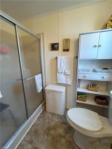 Bathroom with toilet and a shower with door