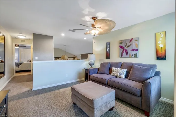 Furnished loft/den area with sleeper sofa, fan.