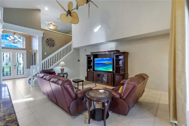 furnished Living room with a towering ceiling, Custom french entry doors.