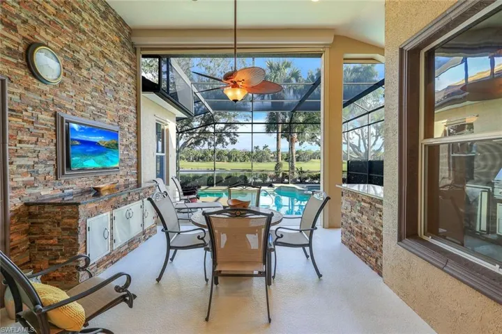 Covered Screened Lanai outdoor living area adjoining summer kitchen area overlooking pool, pond and golf course.
