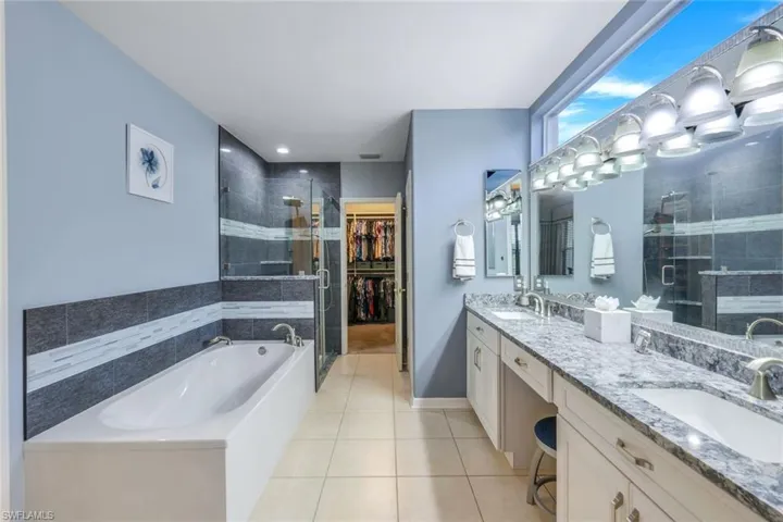 Updated master Bathroom featuring vanity, and separate shower and soaker tub