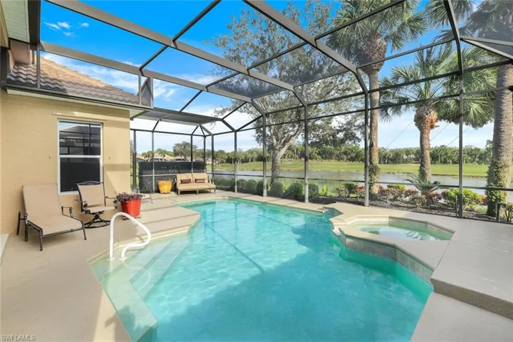 View of furnished pool area featuring gas heated hot tub, overlooking water and golf course