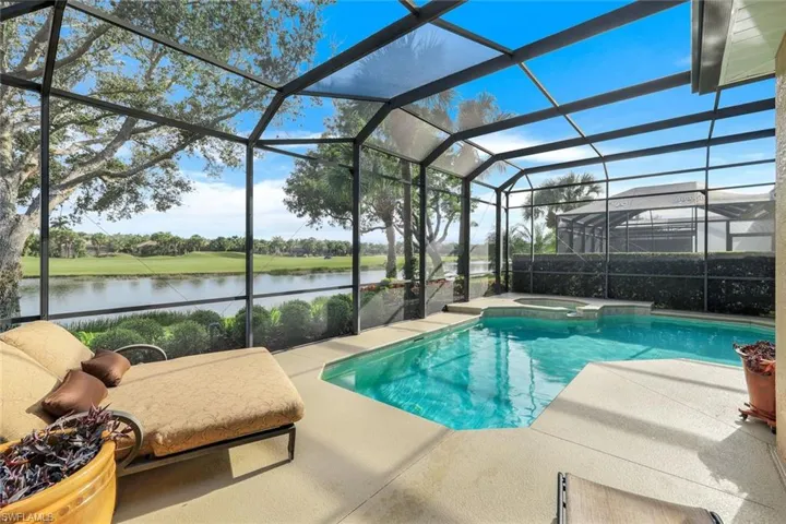 Pool featuring a water view, an in ground hot tub, screened lanai, and a lounging patio area