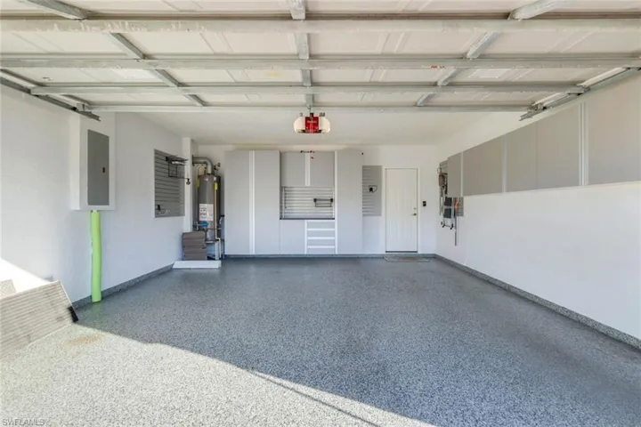 Garage with Custom storage cabinetry and epoxy finished floor.