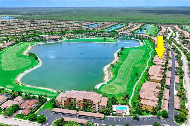 Aerial perspective showcasing a residential community with a large body of water and manicured golf course greens