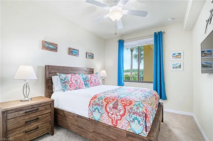Bedroom featuring a wood-finish bed frame, coordinated nightstands with built-in drawers, and a ceiling fan with integrated lighting