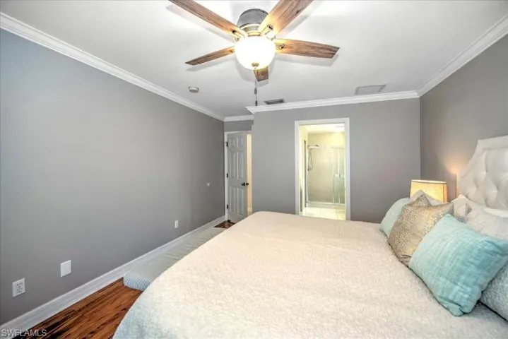 Bedroom featuring crown molding, connected bathroom, ceiling fan, and hardwood / wood-style floors