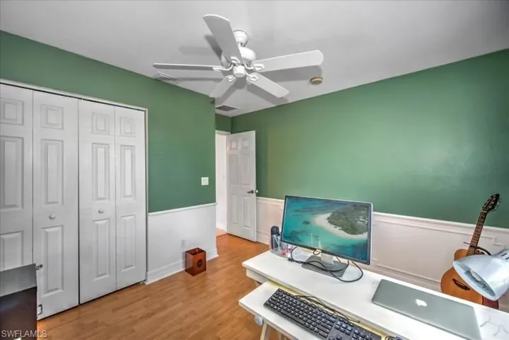 Office area with ceiling fan and light hardwood / wood-style flooring