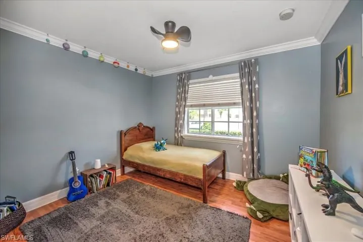 Bedroom with crown molding, ceiling fan, and hardwood / wood-style floors