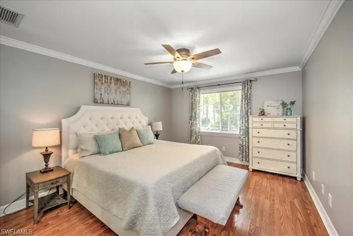 Bedroom with ceiling fan, light hardwood / wood-style flooring, and crown molding