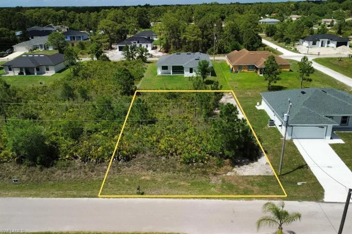 Cleared building lot featuring a level grade and partial tree coverage