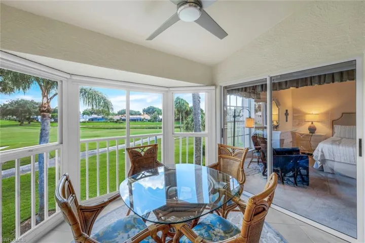 Sunroom with golf course view, lofted ceiling, tile patterned floors, and a textured wall