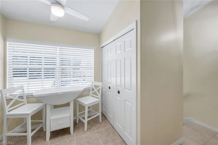 Full Washer/Dryer off Dining space featuring light tile patterned flooring and a ceiling fan