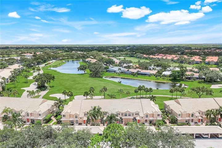 Aerial view of residential area featuring a nearby body of water and a golf club