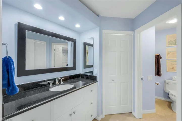 Bathroom featuring vanity, light tile patterned floors, recessed lighting, and a closet