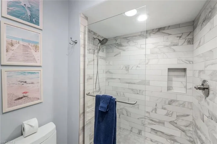 Full bath featuring toilet and a shower stall