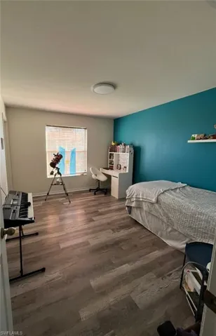 Bedroom with a desk and wood finished floors