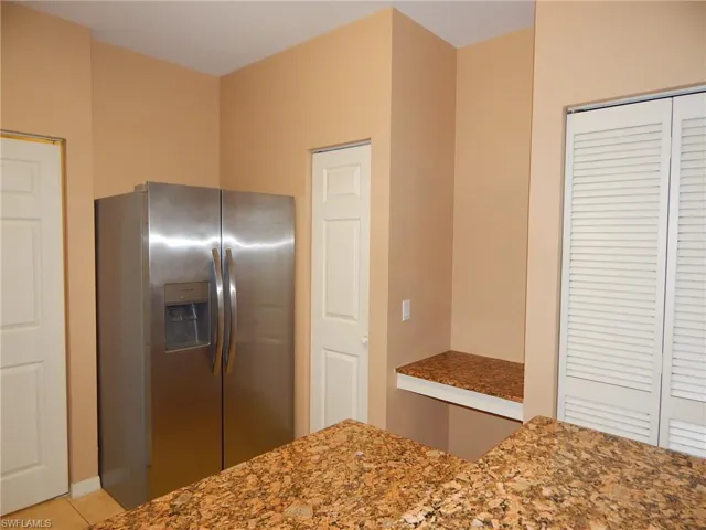 Kitchen featuring stainless steel fridge with ice dispenser and light tile patterned floors