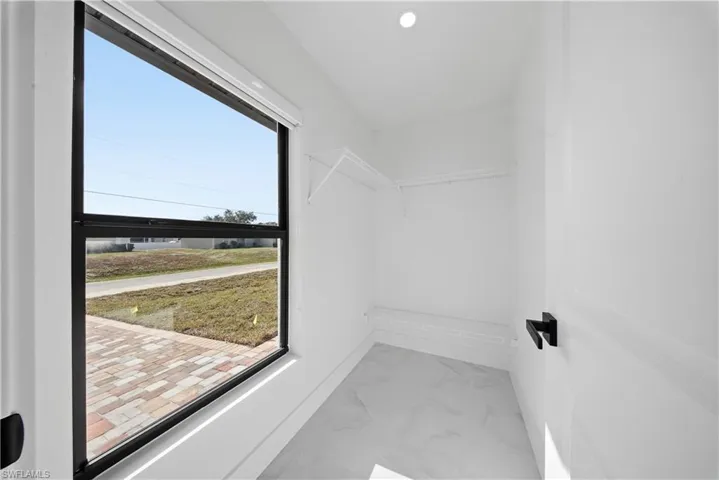 Walk in closet with marble finish floors