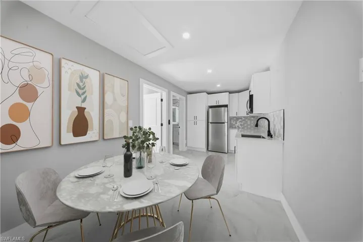 Dining area featuring light marble finish floors and recessed lighting