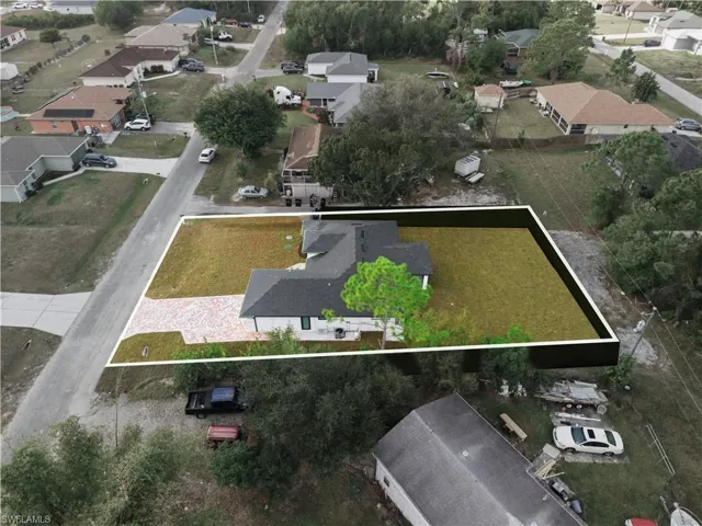 Aerial view of property and surrounding area featuring nearby suburban area and property parcel outlined