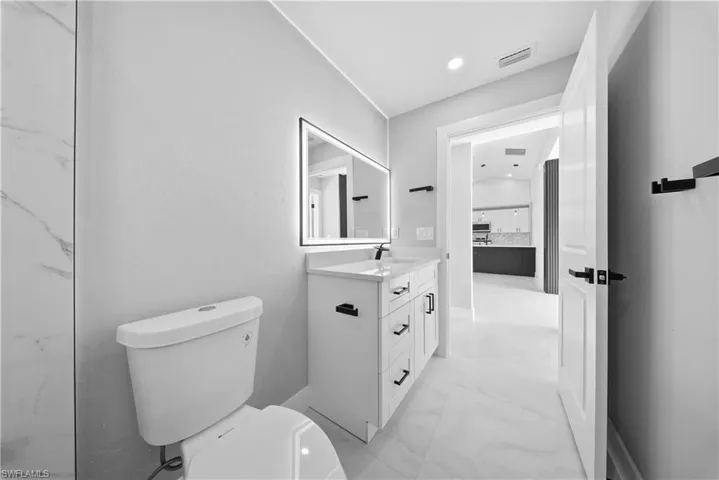 GUEST Bathroom featuring light marble finish floors, vanity, and recessed lighting