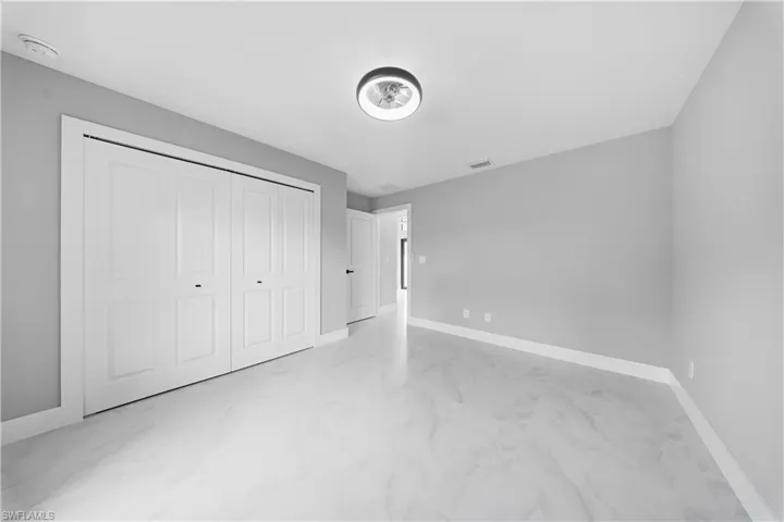 GUEST bedroom#2 featuring concrete flooring and a closet