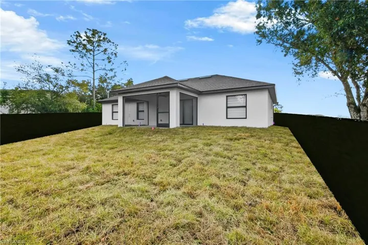 Back of house featuring a fenced backyard, stucco siding, and a sunroom