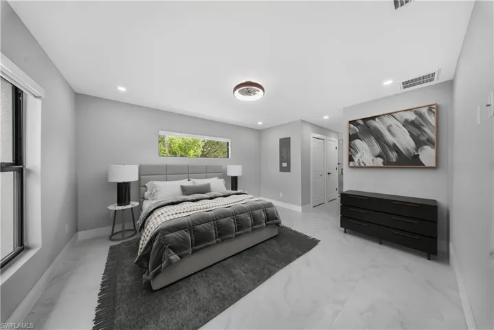 MASTER Bedroom with a TWO WALK IN closets, light marble finish flooring, recessed lighting, and electric panel