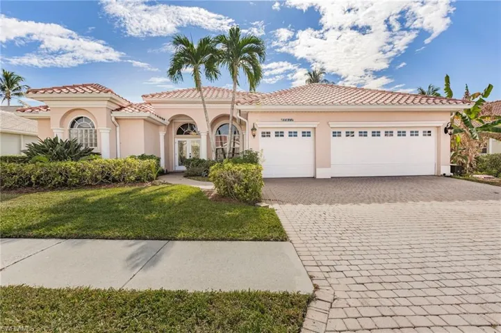 Mediterranean / spanish-style home featuring decorative driveway, stucco siding, a front lawn, an attached garage, and a tiled roof