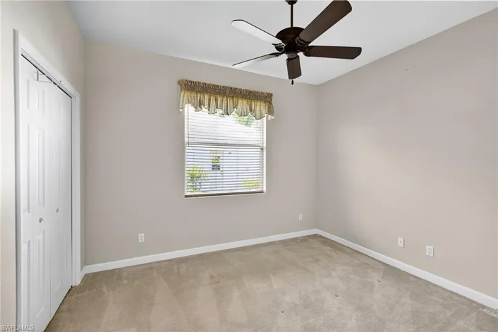 Unfurnished bedroom with a closet, light carpet, and a ceiling fan
