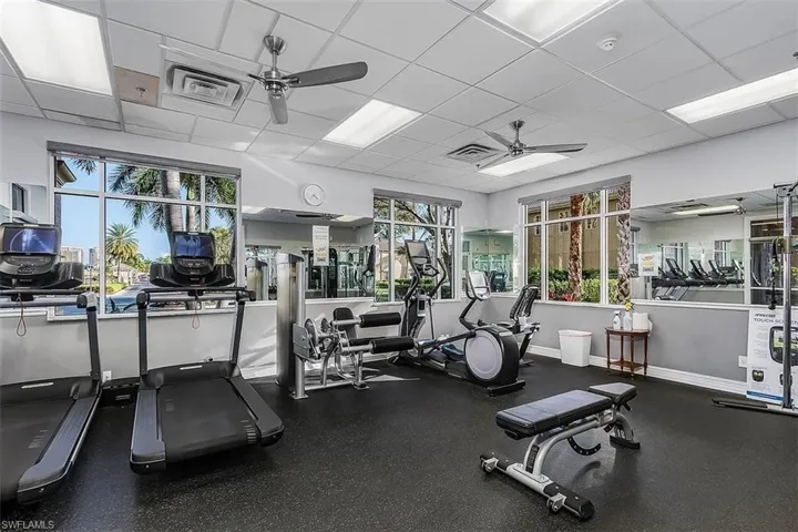 Exercise room with a paneled ceiling and a ceiling fan