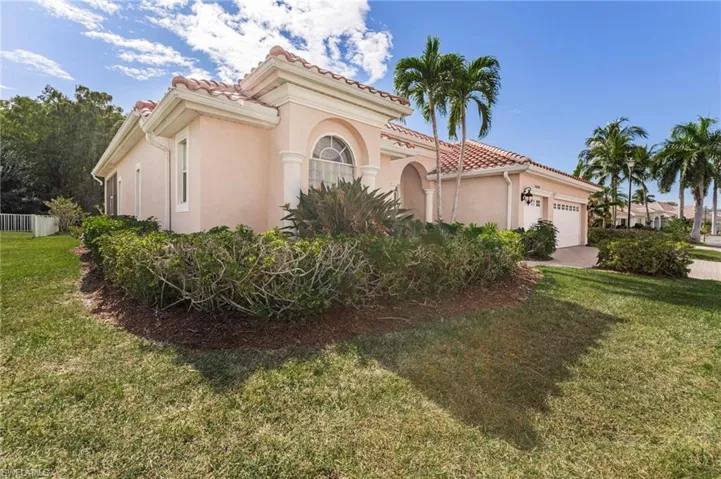 Mediterranean / spanish home with a garage, a front yard, and stucco siding