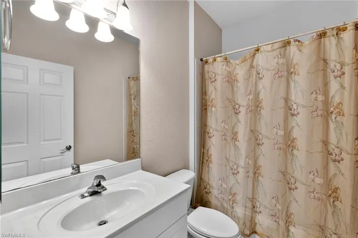 Bathroom featuring vanity, a shower with curtain, and a textured wall