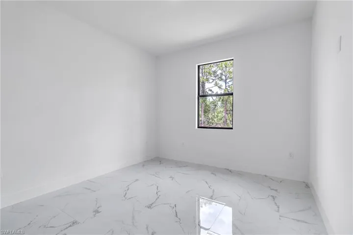 Empty room with marble look tile flooring and baseboards