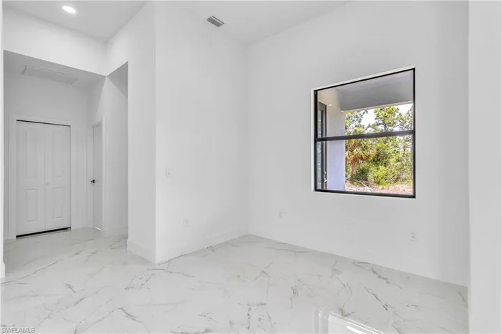 Empty room featuring marble finish floors and baseboards