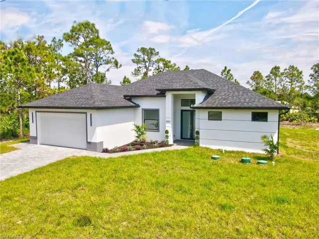 Prairie-style house with a garage, roof with shingles, decorative driveway, and a front yard